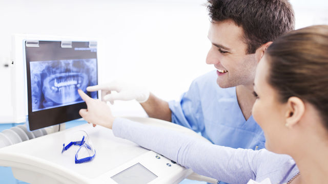 Dentist and patient looking a panoramic x-ray
