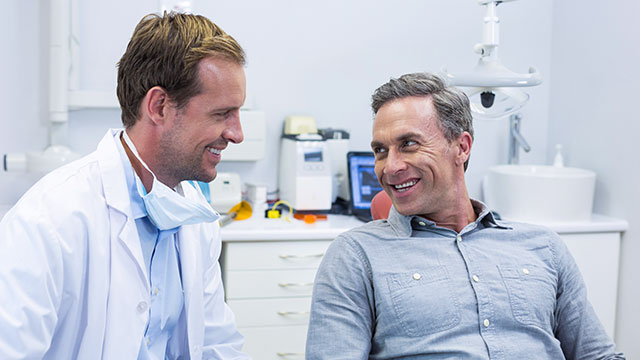 Smiling dentist and patient interacting with each other