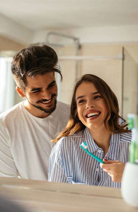 couple smiling while using colgate toothbrushes couple smiling while using colgate toothbrushes
