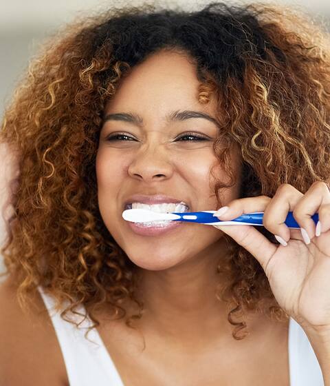 woman in mirror brushing her teeth woman in mirror brushing her teeth