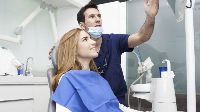 a dentist showing an x-ray to the patient