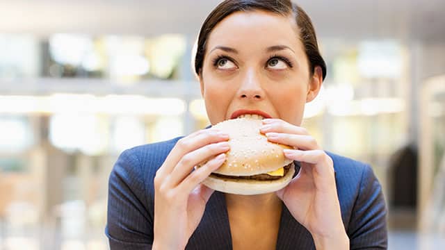 Young woman is eating a hamburger