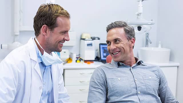 A dentist and a patient talking Smiling dentist and patient interacting with each other