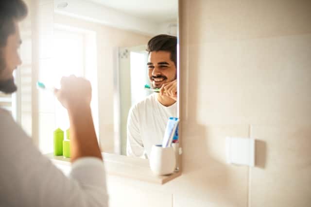 Man brushing teeth with fluoride toothpaste